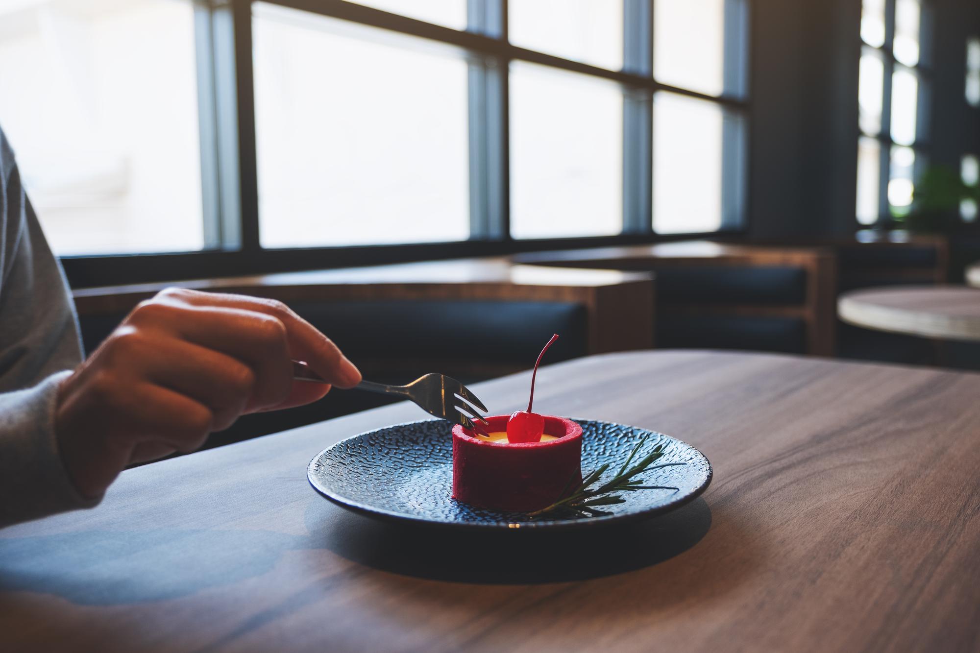 Hand arranging dessert components on slate